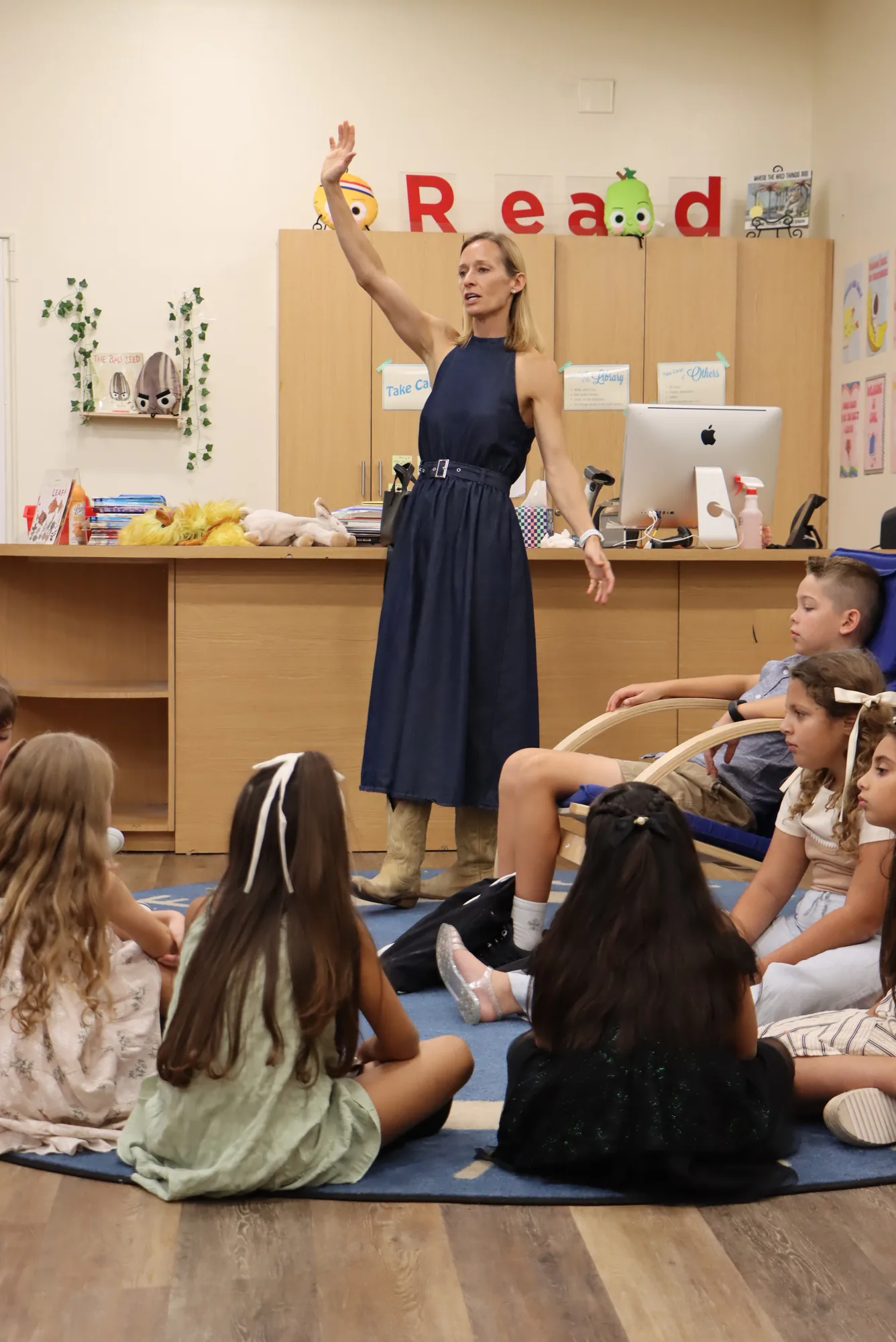 Heidi Drake teaching a room of Christchurch Kids seated on the rug