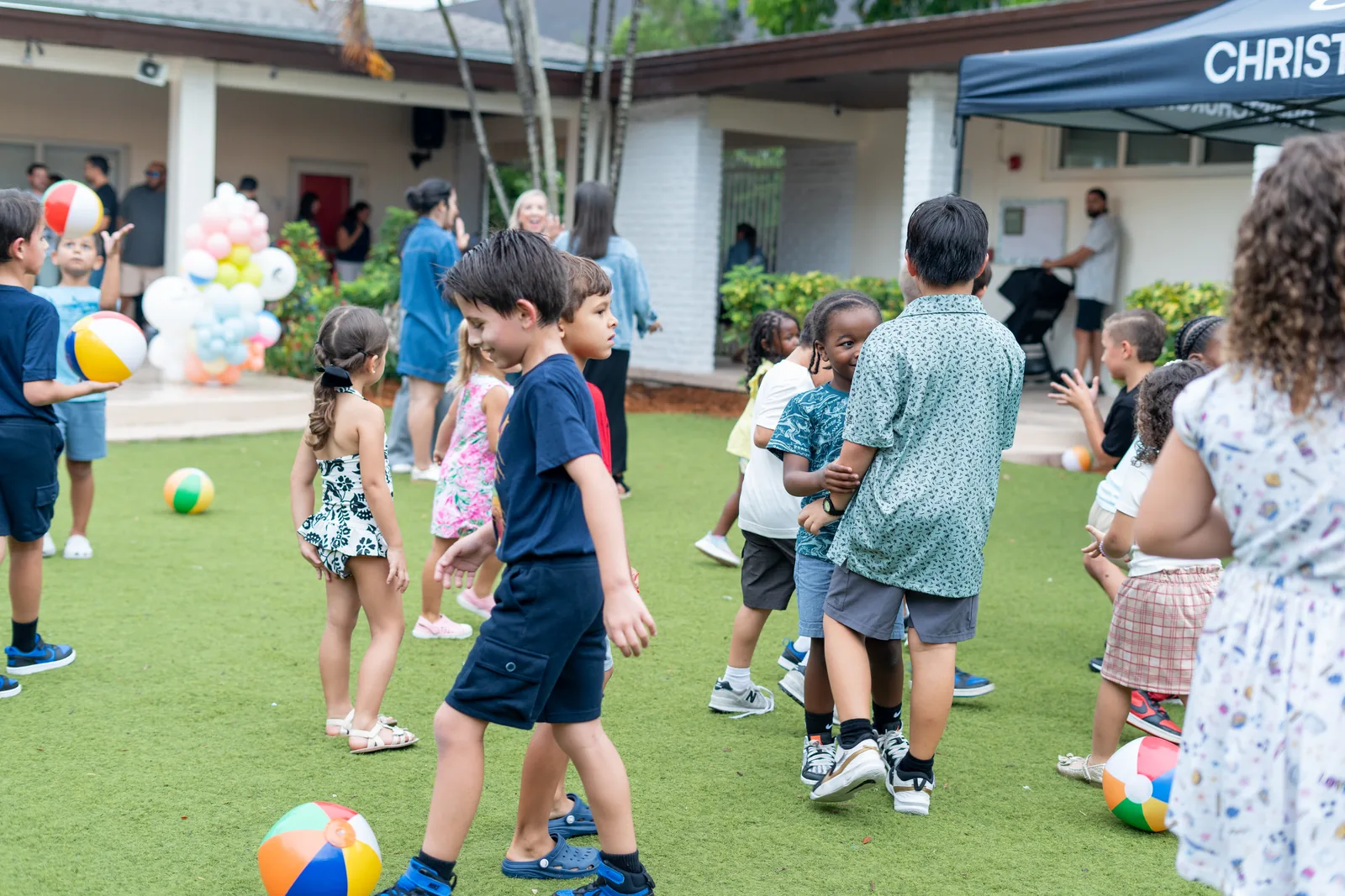Children playing with beach balls on the turf at a family event