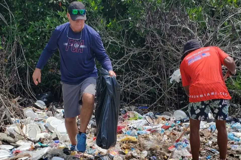 Leaders Unlimited volunteers clearing trash from a mangrove shoreline