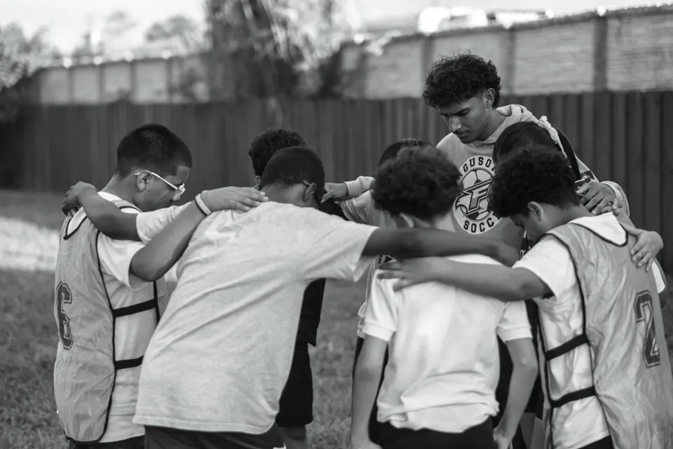 Young people in a team huddle at City Life KIX