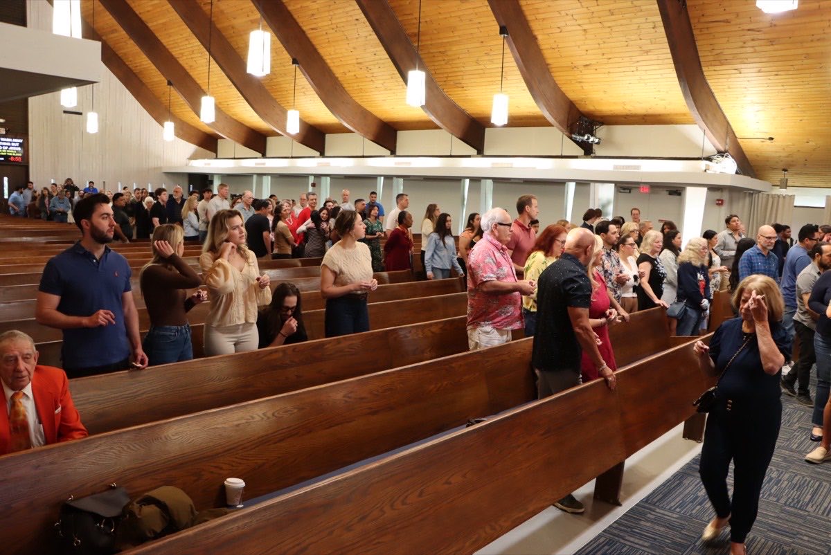 The congregation standing during worship at Christchurch Miami