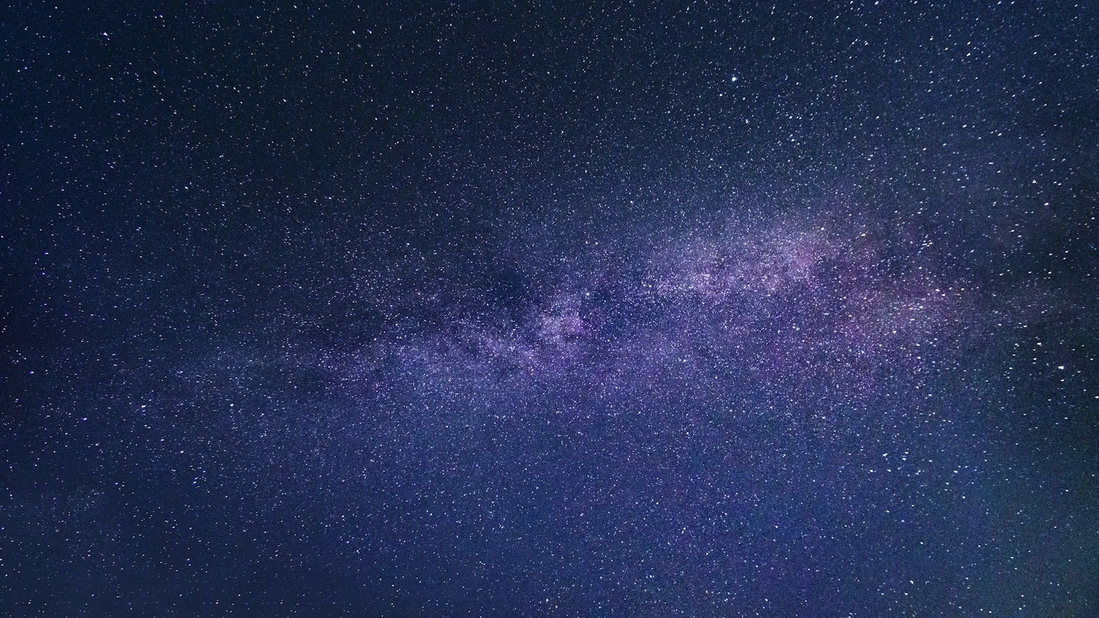 The Milky Way arcing across a deep, star-filled night sky.