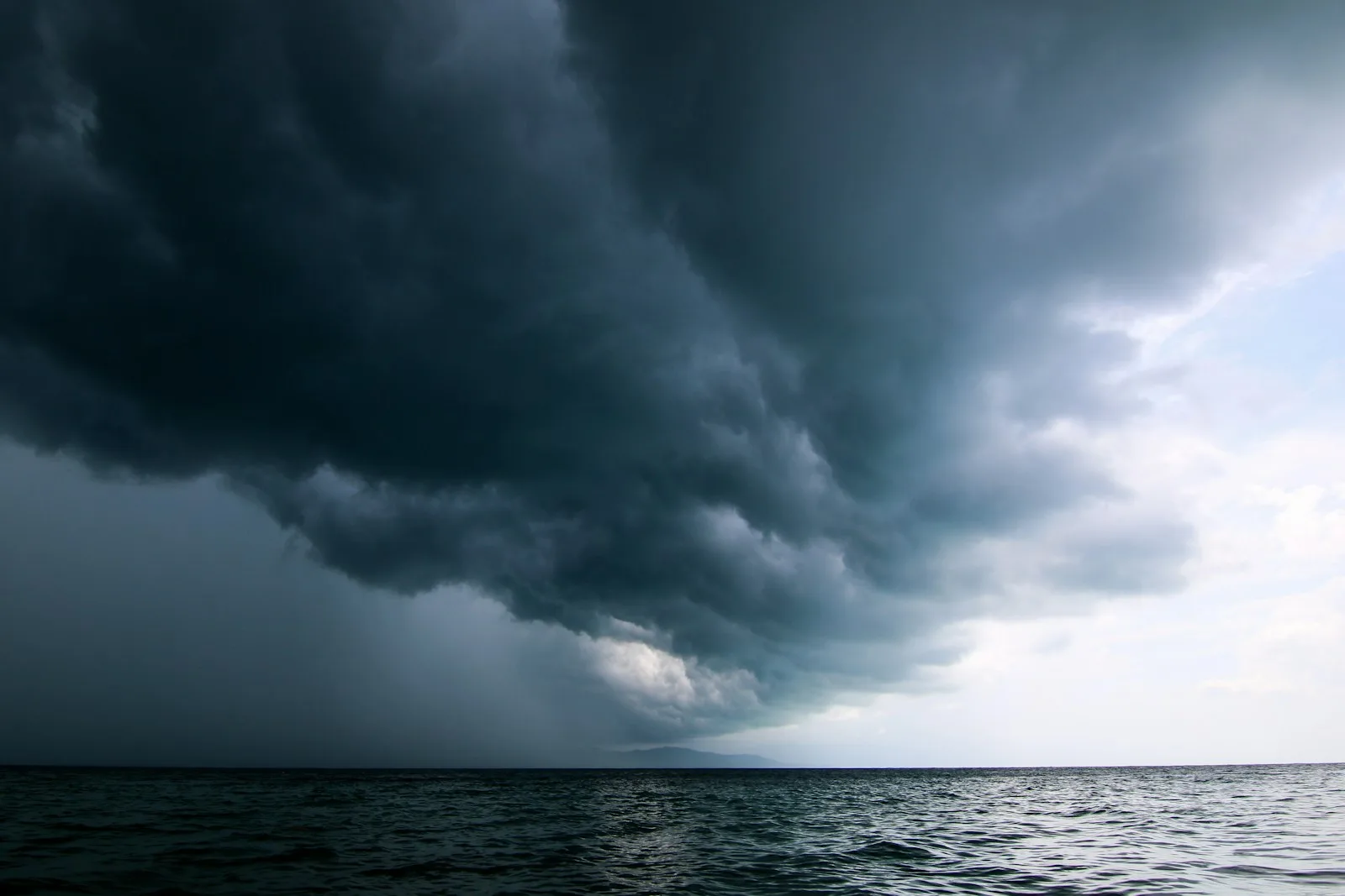 A large storm moving across the sky over open water